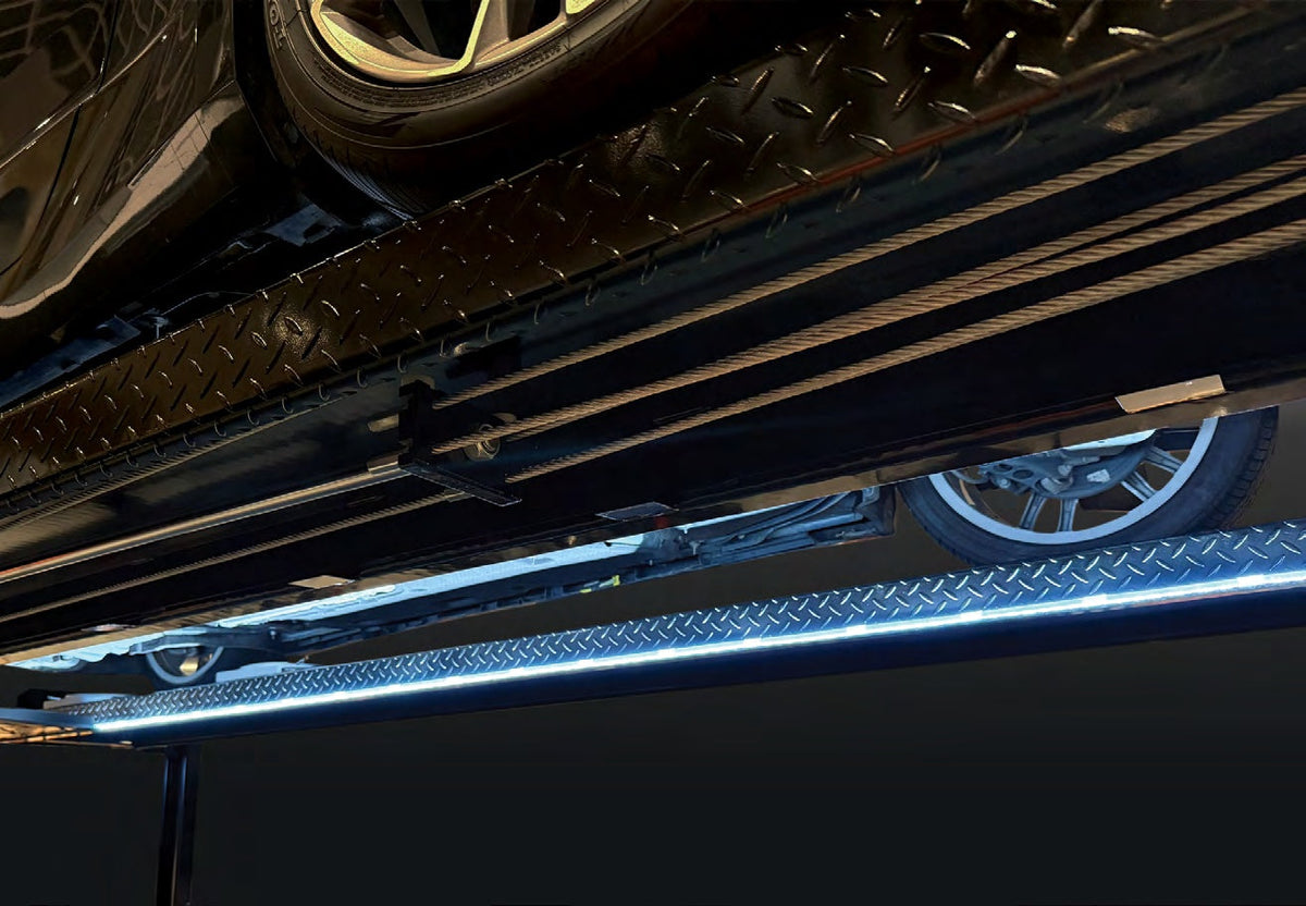 Side view of an Atlas LED lift light strip mounted along a 4-post lift runway